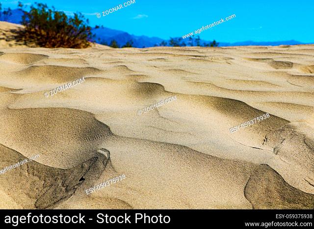 Sand dunes on the background of mountains and blue sky