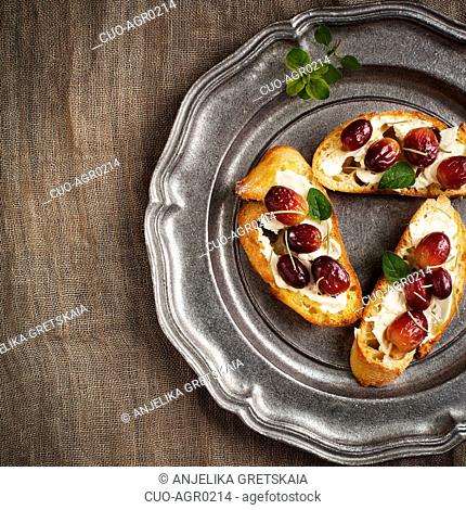 Crostini with goat cheese, grapes and rosemary