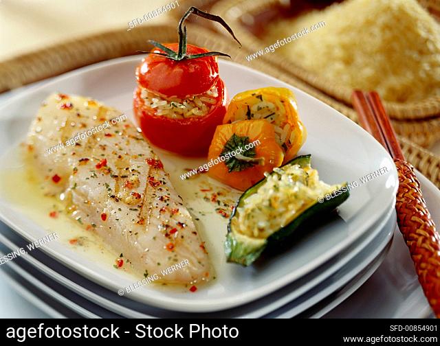 Grilled fish fillet with rice, stuffed peppers and courgettes