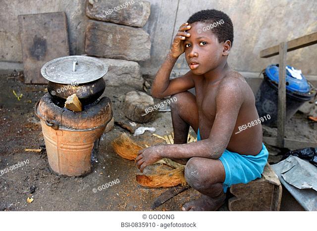 Child inhabitant of Togo near the stockpot outside his home