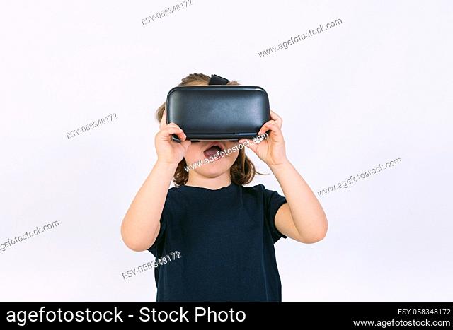 Little girl wearing virtual reality glasses with hands hold goggles on white background