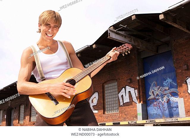 Man playing guitar, smiling