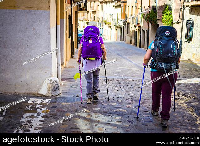 Pilgrims with backpack walking through the narrow streets of Navarrete, La Rioja, Spain, Europe