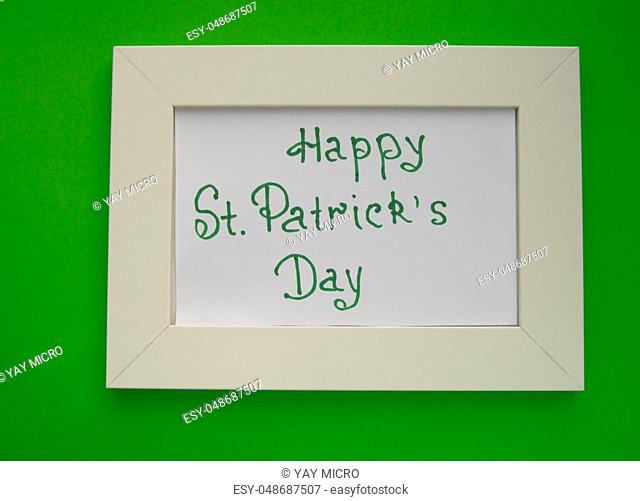Happy St. Patrick's Day greeting card with white frame on green background