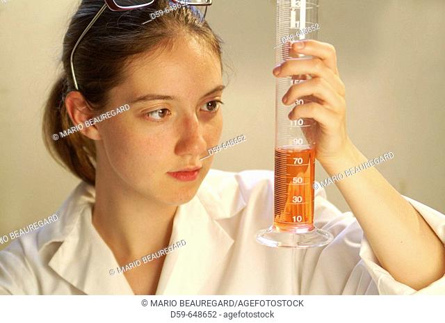 Lab technician looking at beaker