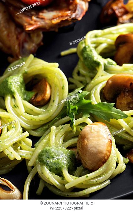 Pasta with pesto and roasted chicken closeup