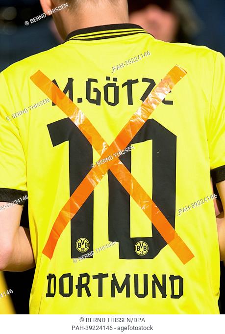 A fan of Borussia Dortmund (BVB) wears a jersey with the crossed-out number of Mario Goetze during the Bundesliga soccer match between Borussia Dortmund and FC...