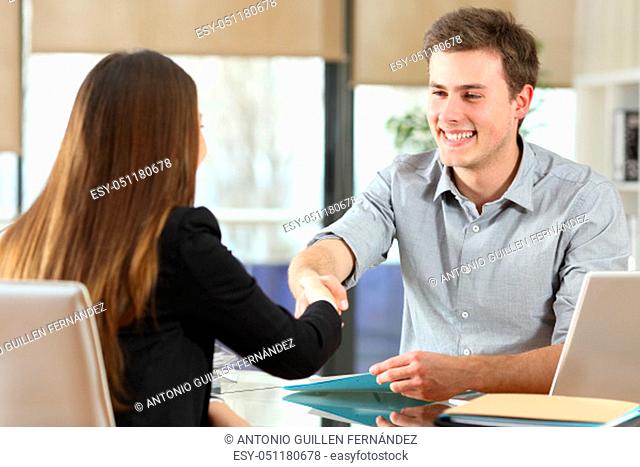 Happy businesspeople handshaking after negotiation at office