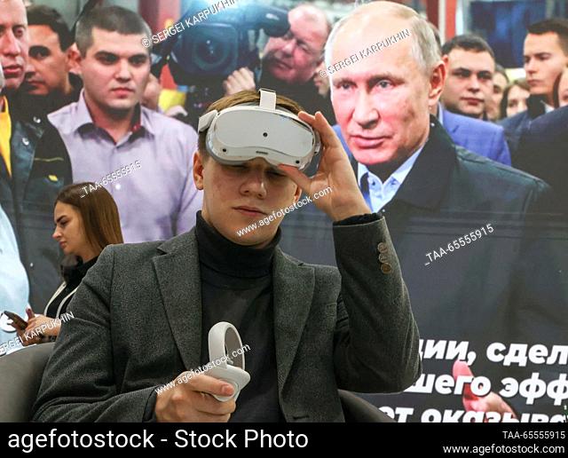 RUSSIA, MOSCOW - DECEMBER 8, 2023: A young man wears a VR headset by a stand of the Zaporozhye Region at the Russia Expo international exhibition and forum at...