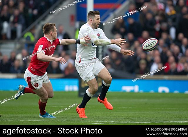 07 March 2020, Great Britain, London: Elliot Daly (England, 15) is interrupted on the left by Nick Tompkins (Wales, 13). Fourth matchday of the Guinness Six...