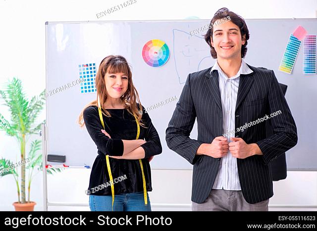 Young female tailor taking measurements for formal suit