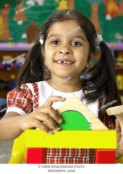 South Asian Indian girl playing with toys in nursery school MR