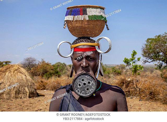 Mursi Woman Wearing A Lip Plate and Carrying A Basket On Her Head, Mursi Tribal Village, The Omo Valley, Ethiopia