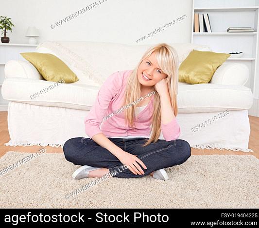 Attractive blonde female posing while sitting on the floor