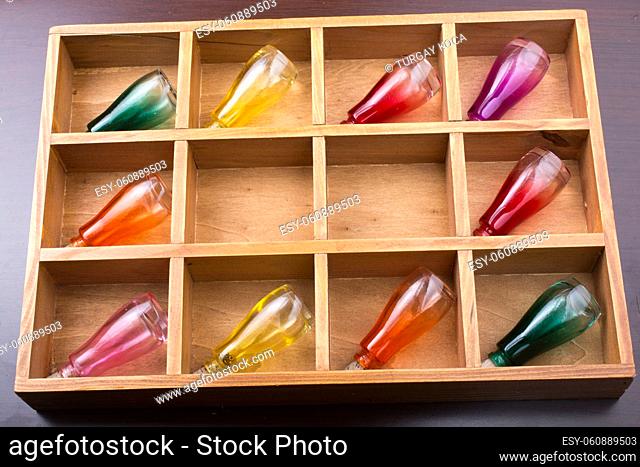 Colorful small bottles in a wooden box in the view
