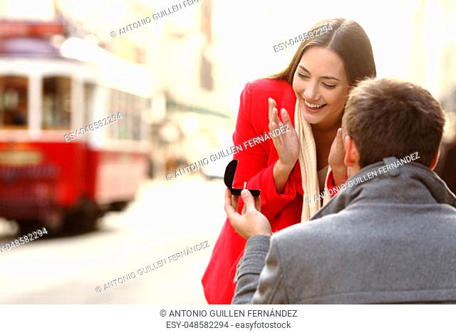 Vintage marriage proposal outdoors in the streets of portugal with a red tram in the background