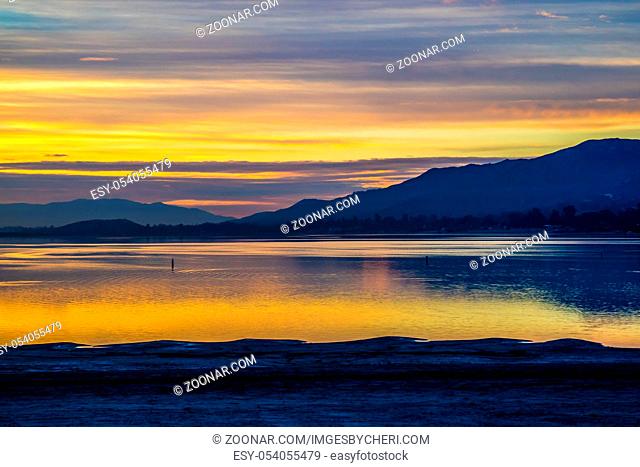 Romantic sunset in a lake with orange and blue cloudy sky