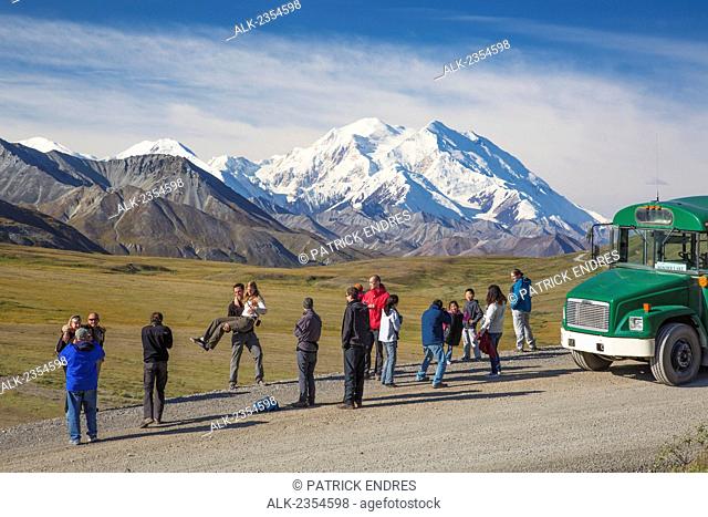 Tourists from a Denali Park bus tour view the summit of Mount McKinley from a Stony Dome, Denali National Park; Alaska, United States of America