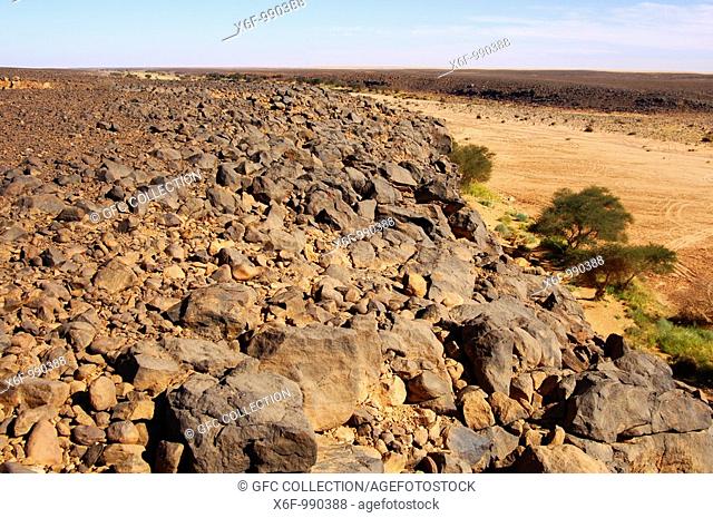 View across a dry river bed in the Wadi Mathendous on the stony Mesak Settafet plateau, Fezzan, Libya