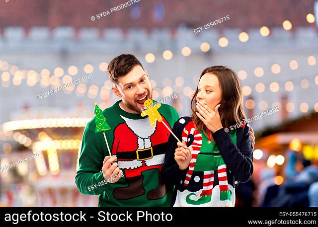 couple with christmas party props in ugly sweaters