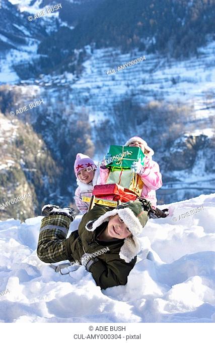 Children playing in snow with presents