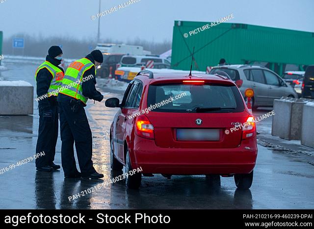 16 February 2021, Saxony, Breitenau: Two police officers of the Federal Police checking travellers and commuters at the parking lot Am Heidenholz on the A17...