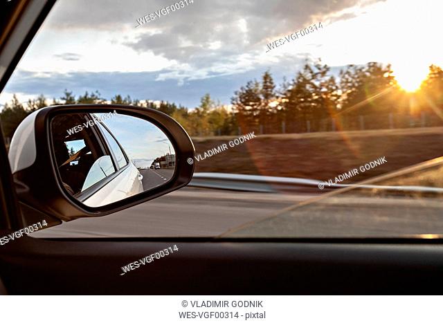 Voronezh, Voronezh Oblast, Russia, Shiny side-view mirror with sun setting in background