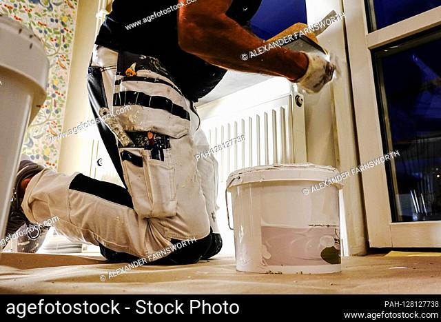 Stockholm, Sweden A painter using a paint can on the floor in a kitchen being painted. | usage worldwide. - STOCKHOLM/Sweden