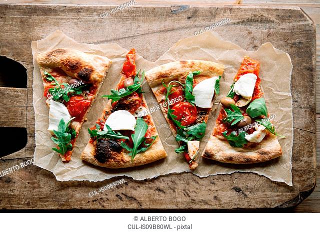 Pizza slices on chopping board, overhead view
