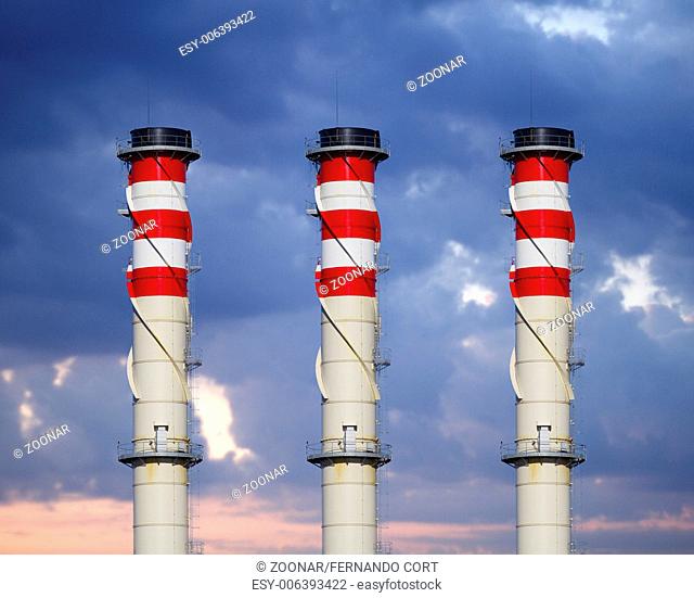 industrial chimneys on cloudy sky at sunset
