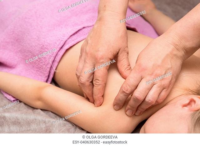 the masseur gives the child a back massage, the girl clearly enjoys it