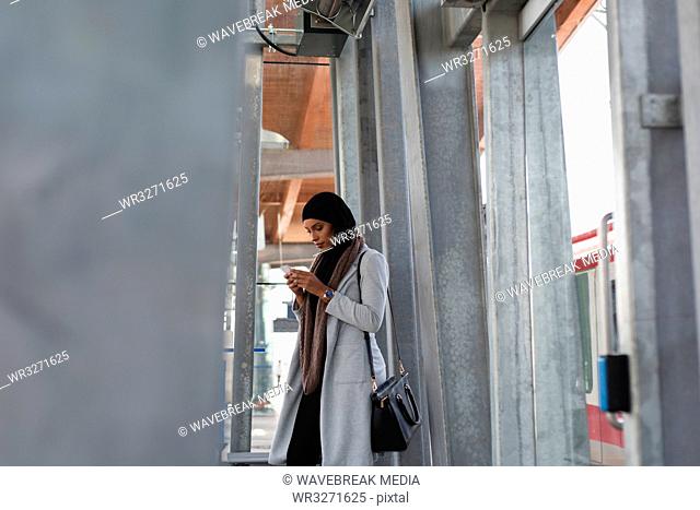 Woman using mobile phone in platform
