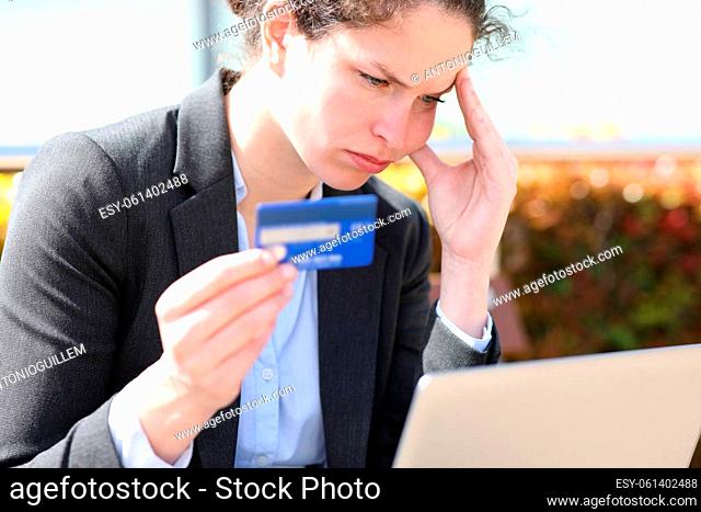 Worried businesswoman complaining buying online with credit card and laptop