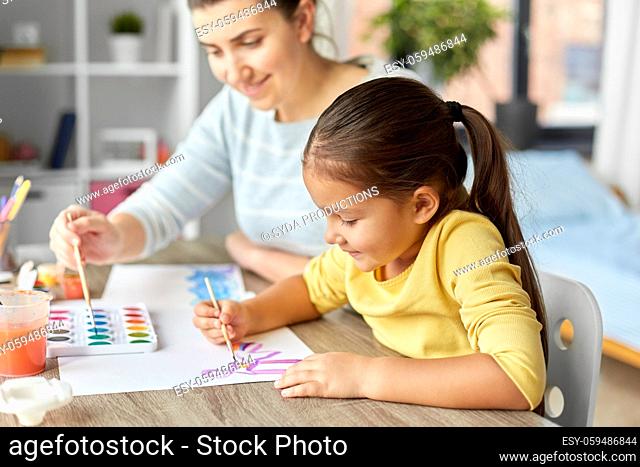 mother with little daughter drawing at home