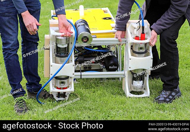 13 May 2020, Saxony-Anhalt, Seegebiet Mansfelder Land: Members of a research group are mounting a high-resolution 3D laser on a diving robot for use in the...