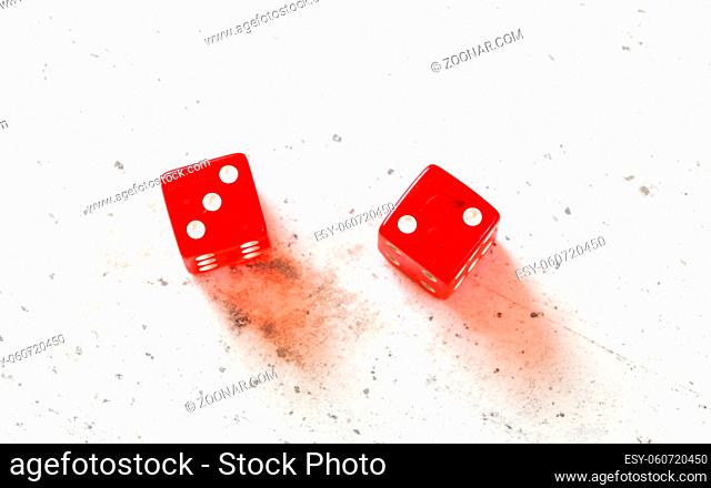 Two red craps dices showing Fever Five Little Phoebe number three and two overhead shot on white board.