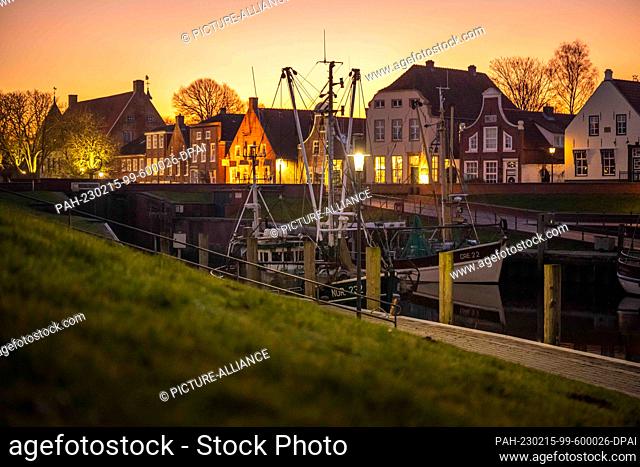 PRODUCTION - 14 February 2023, Lower Saxony, Greetsiel: Shrimp cutters lie in the harbor at sunset. The new North Sea Tourism Agency (Tano) wants to start...