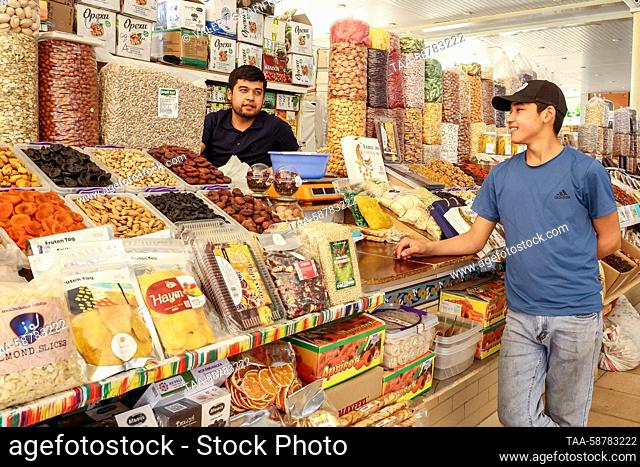 UZBEKISTAN, TASHKENT - MAY 1, 2023: Men at a stall selling nuts and dried fruit at Oloy Bazaar. Valery Sharifulin/TASS
