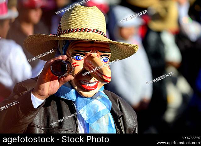 Mask of a man with a beer bottle at the parade on the eve of Inti Raymi, Festival of the Sun