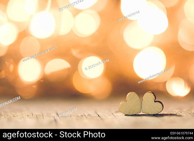 Two handmade wooden hearts on beautiful golden bokeh background. Vintage style. Love Valentine's Day concept