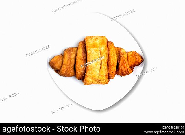 top view of franzbrotchen pastry on plate isolated on white background