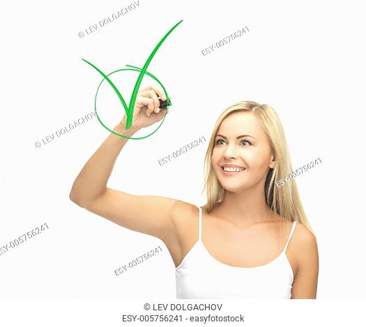 smiling woman in white shirt drawing green checkmark