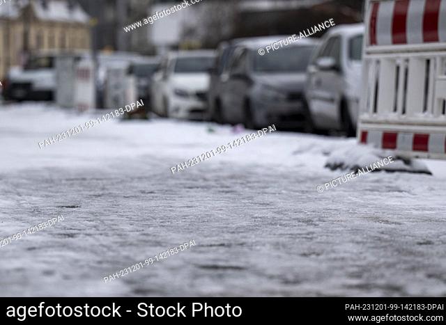 PRODUCTION - 30 November 2023, Berlin: View of an icy sidewalk. The consequences of the winter weather in Berlin are slippery roads and sidewalks