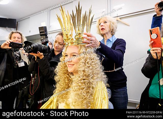 16 November 2023, Bavaria, Nuremberg: Nelli Lunkenheimer (M), the new Nuremberg Christkind, gets her wig put on by Helke Hadlich (r)