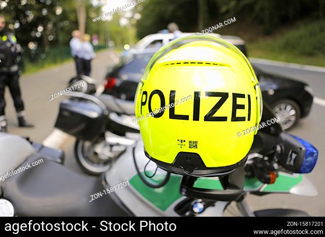 Symbolbild Polizeikontrolle, vorne Motorradhelm hinten kontrollierende Polizeibeamte, Wipperfürth, Bergisches Land, NRW; Deutschland