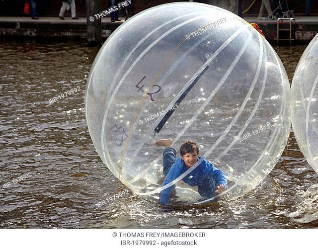 Children in an air ball on the water, Emden, Lower Saxony, Germany, Europe