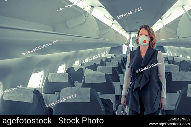 woman on board of aircraft with respirator on head. protect themselves against viral disease. People cancel travel abroad due to coronavirus