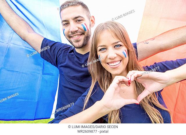 Female soccer fan forming heart with hands