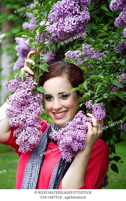 A young woman with lilacs in Spokane, Washington, USA