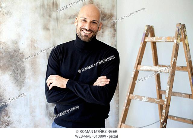 Portrait of man with crossed arms wearing black turtleneck